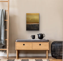 Load image into Gallery viewer, Studio Brambilla Aware Winning Toronto Artist: Home Decor: This pretty much depicts life don't you think. The sky is a beautiful gold but the seas are quite rough. The good and bad. The Yin and Yang. A thought provoking composition. I wanted to feel the roughness of the water so I used Venetian Plaster on a wood panel to get the rough texture and the sky is painted with high end metallic gold paint. If you look closely you'll see the sun breaking through...so there is a happy ending!