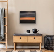 Load image into Gallery viewer, Studio Brambilla Aware Winning Toronto Artist: Home Decor: As you're dreaming, you see the light on the horizon surrounded by a bronze glow. The rest of the sky and water are black to dark grey and there is a cloud floating above... or is that an island in the sky? Relax. You are entering a peaceful place and looking forward to exploring the light. At 24"x30" this oil on canvas work is suitable for medium sized spaces finished smartly with a black floating frame.